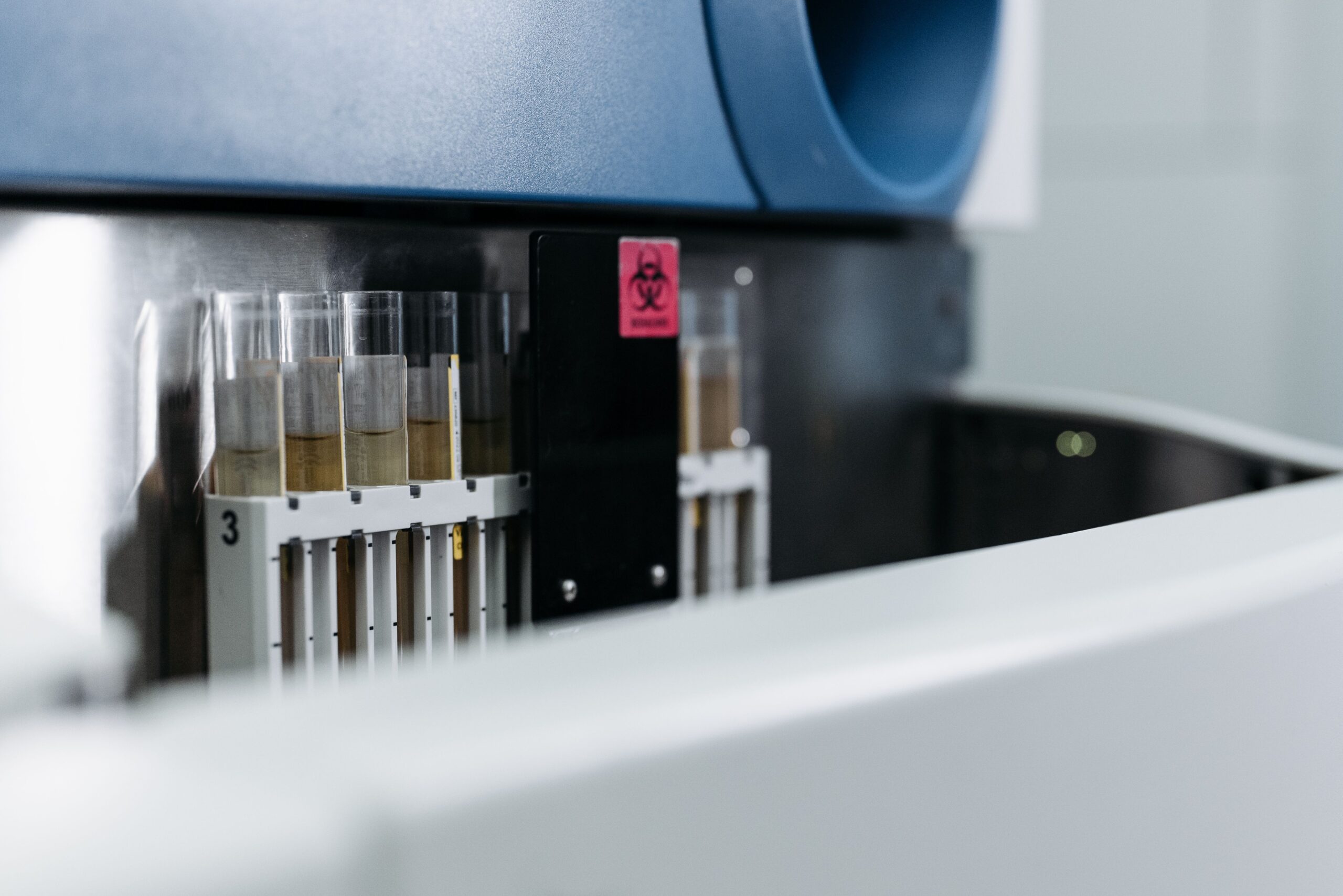 Close-up of test tubes in laboratory with biohazard sign, representing medical research environment.